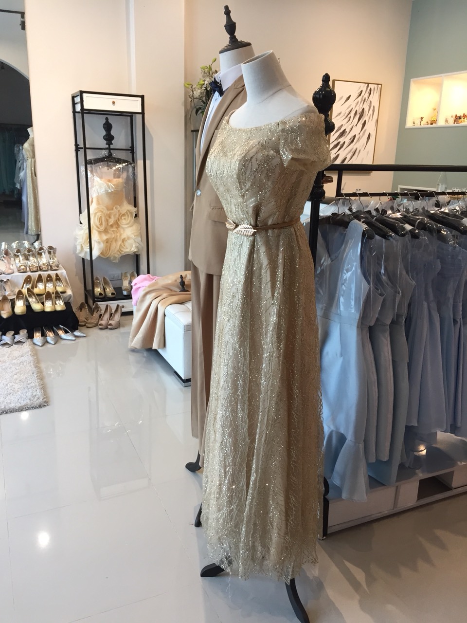 พร้อมเช่า ชุดราตรียาว แบบไหล่ปาดแขนสั้น สีทอง แต่งเม็ดกากเพชรทั้งชุด มาพร้อมเข็มขัดรูปใบไม้สีทอง หรูมาก