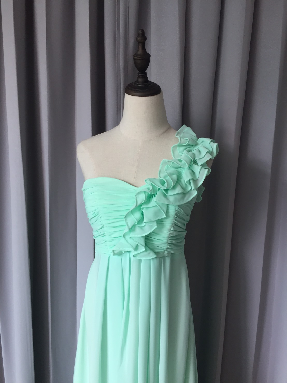 พร้อมเช่า ชุดราตรียาว ไหล่เดียว จับเดรปหน้าอก แต่งระบายช่วงไหล่ สีเขียวอ่อน