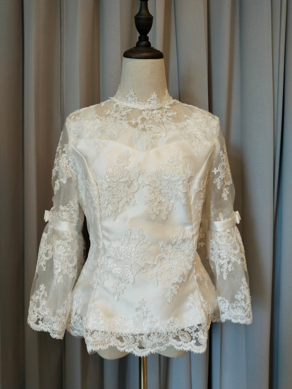 พร้อมเช่า เสื้อลูกไม้สีขาว คอปีน แขนยาวแต่งระบายคาดโบว์ ซิปหลัง (เฉพาะเสื้อ)