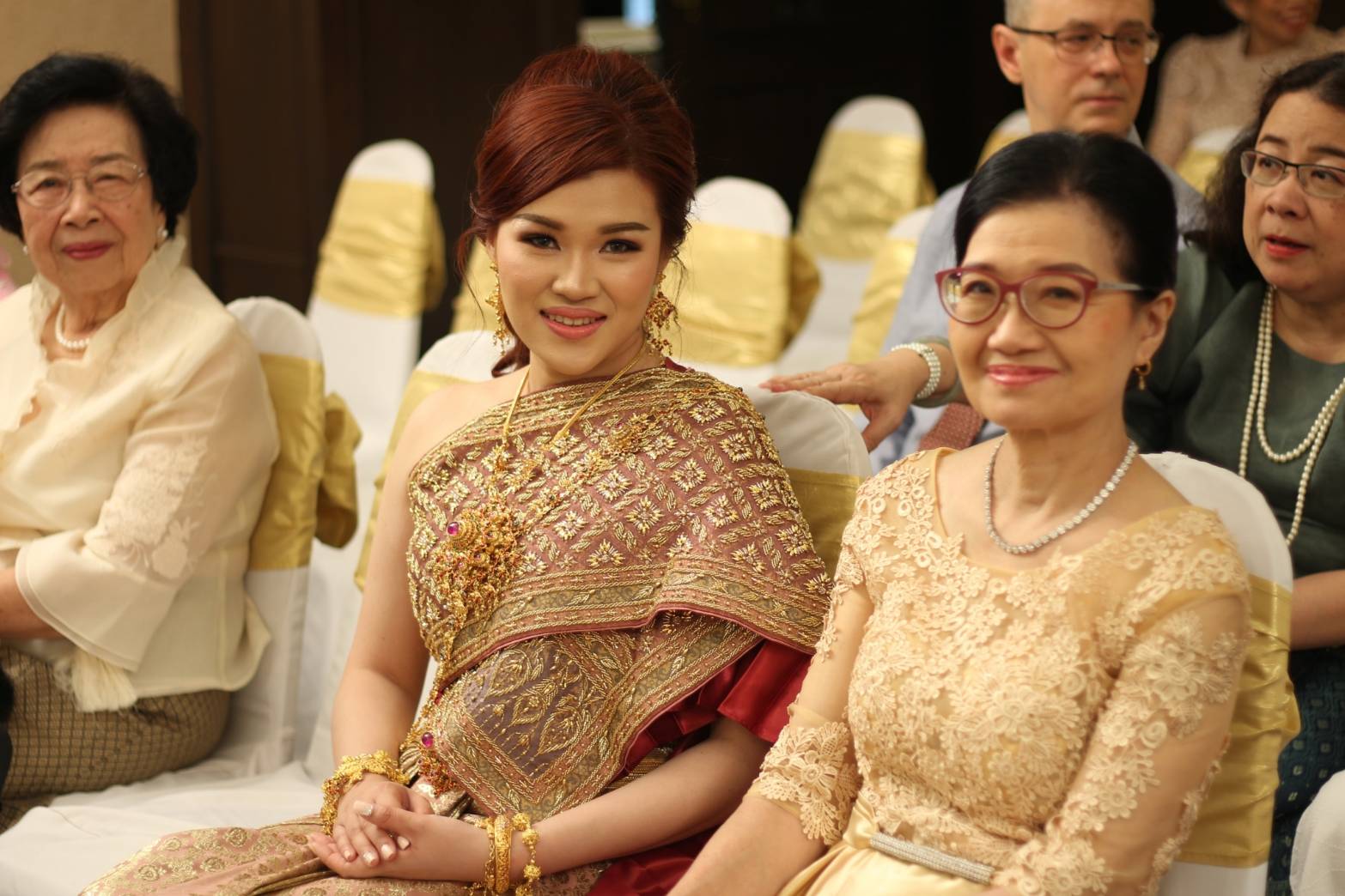 พร้อมเช่า ชุดราตรียาว แขนสามส่วน สีทอง อกแต่งลูกไม้ กรโปรงเนื้อผ้ามัน คาดเอวคริสตัล เพิ่มเข็มกลัดโบว์ช่วงหลัง