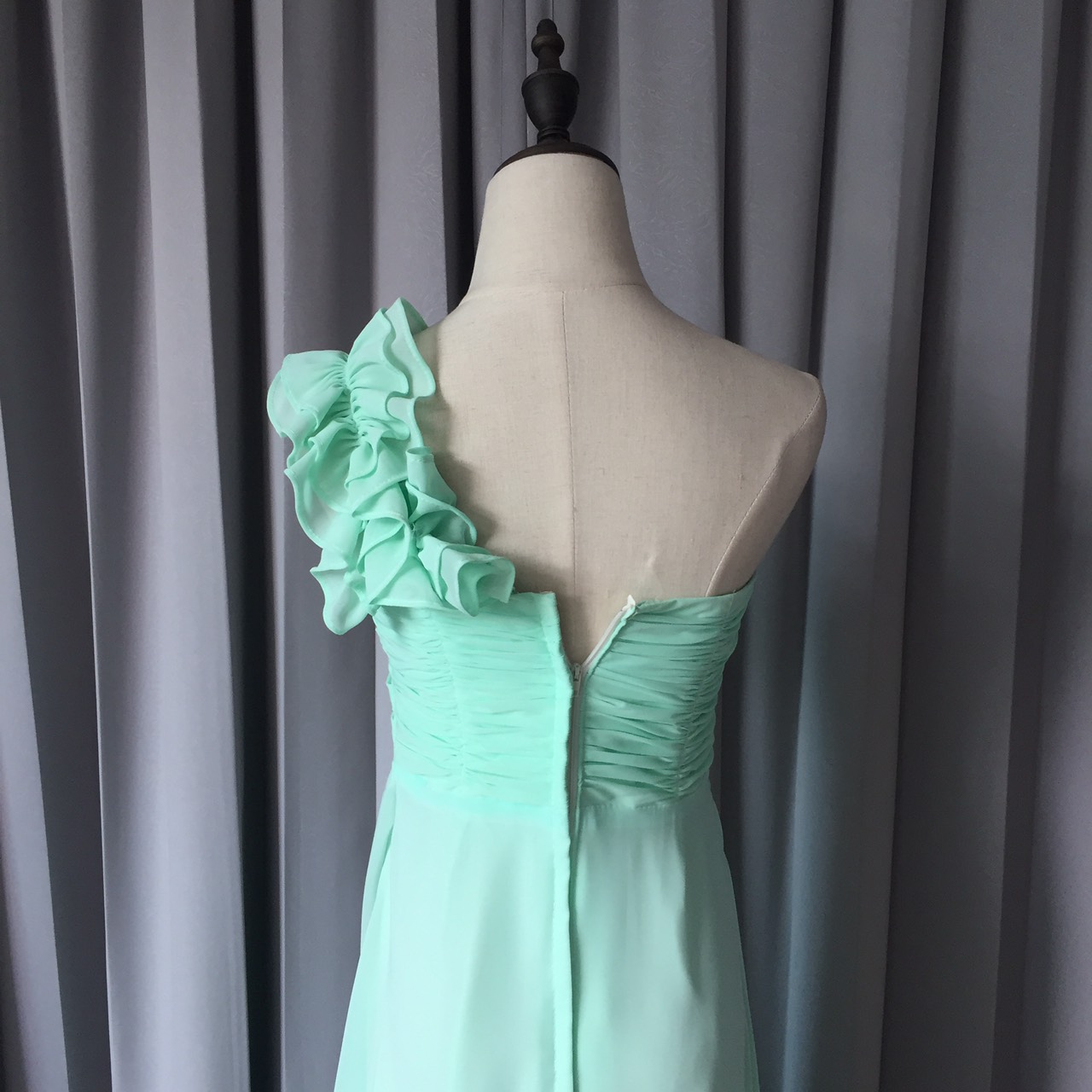 พร้อมเช่า ชุดราตรียาว ไหล่เดียว จับเดรปหน้าอก แต่งระบายช่วงไหล่ สีเขียวอ่อน