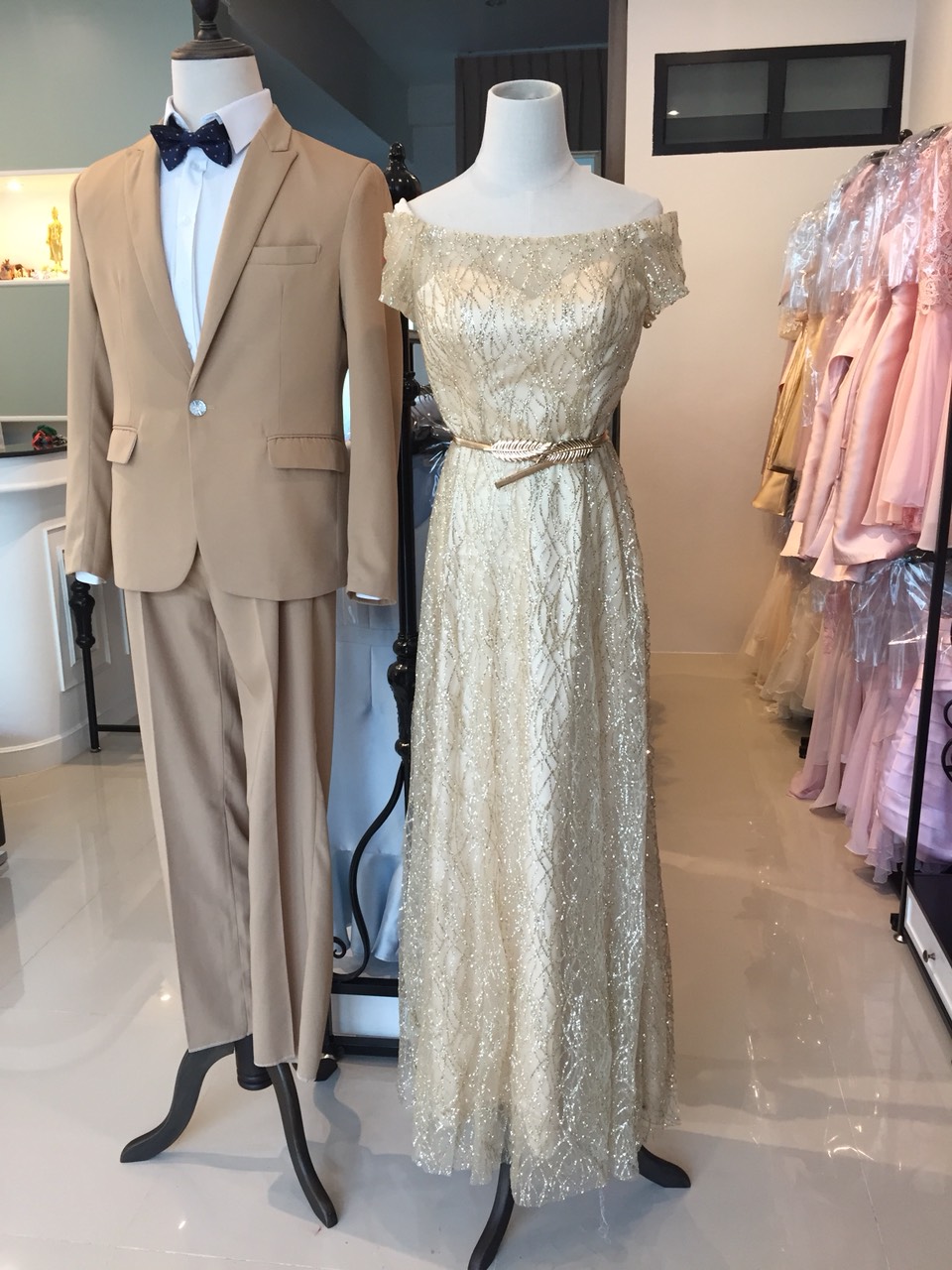พร้อมเช่า ชุดราตรียาว แบบไหล่ปาดแขนสั้น สีทอง แต่งเม็ดกากเพชรทั้งชุด มาพร้อมเข็มขัดรูปใบไม้สีทอง หรูมาก