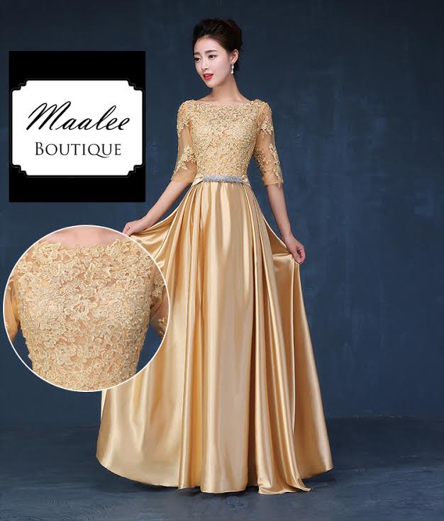 พร้อมเช่า ชุดราตรียาว แขนสามส่วน สีทอง อกแต่งลูกไม้ กรโปรงเนื้อผ้ามัน คาดเอวคริสตัล เพิ่มเข็มกลัดโบว์ช่วงหลัง