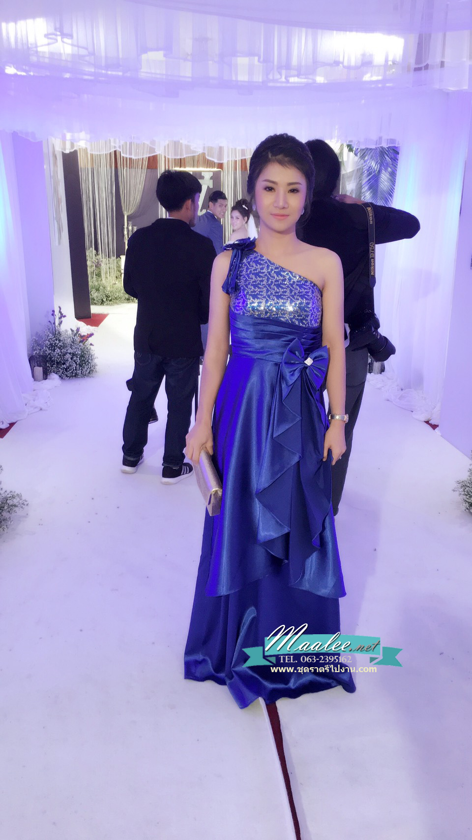 พร้อมเช่า ชุดราตรียาว ไหล่เฉียง สีน้ำเงิน ปักเลื่อมไล่สี จับจีบแต่งโบว์ช่วงเอว ประดับดอกไม้สวยหวานบนไหล่