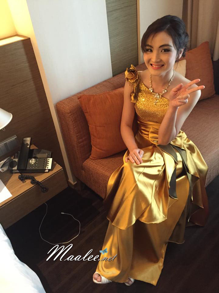 พร้อมเช่า ชุดราตรียาว ไหล่เฉียง สีทอง ปักเลื่อมไล่สี จับจีบแต่งโบว์ช่วงเอว ประดับดอกไม้สวยหวานบนไหล่