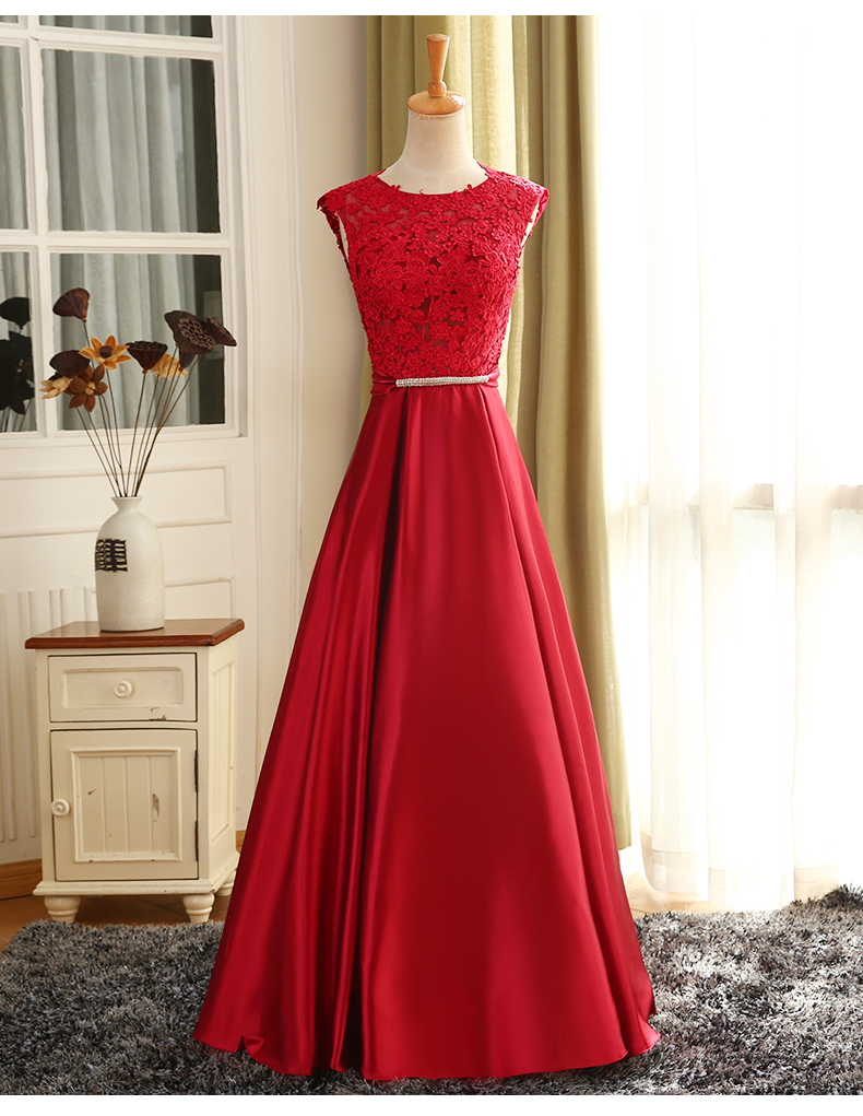 พร้อมเช่า ชุดราตรียาว แขนกุด สีแดง อกแต่งลูกไม้ กรโปรงเนื้อผ้ามัน คาดเอวคริสตัล เซ็กซี่ผ้าหลัง เพิ่มเข็มกลัดโบว์ช่วงหลัง