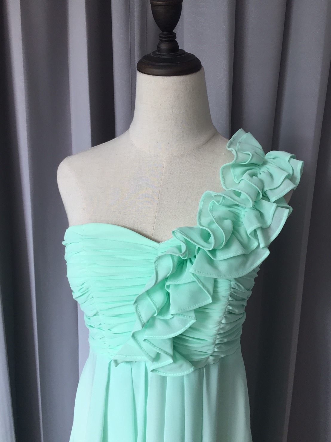 พร้อมเช่า ชุดราตรียาว ไหล่เดียว จับเดรปหน้าอก แต่งระบายช่วงไหล่ สีเขียวอ่อน