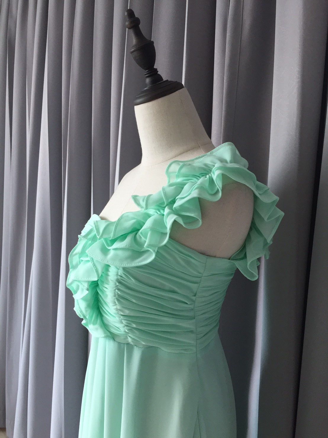 พร้อมเช่า ชุดราตรียาว ไหล่เดียว จับเดรปหน้าอก แต่งระบายช่วงไหล่ สีเขียวอ่อน