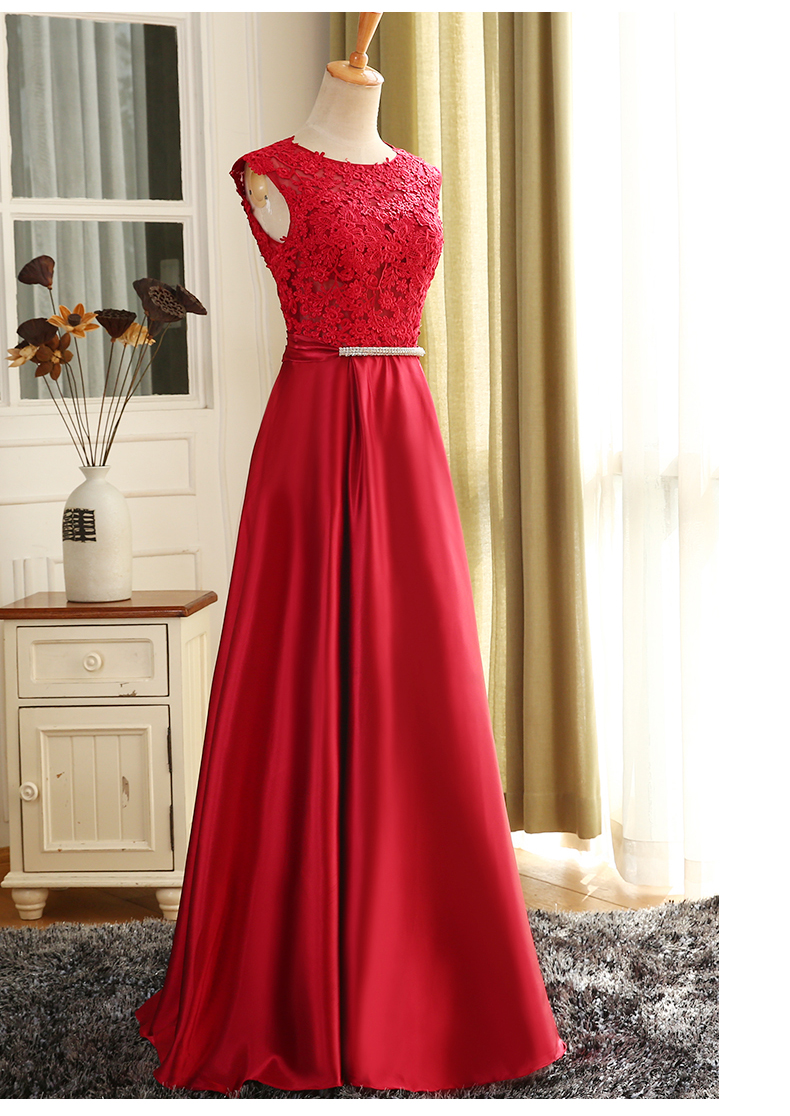 พร้อมเช่า ชุดราตรียาว แขนกุด สีแดง อกแต่งลูกไม้ กรโปรงเนื้อผ้ามัน คาดเอวคริสตัล เซ็กซี่ผ้าหลัง เพิ่มเข็มกลัดโบว์ช่วงหลัง