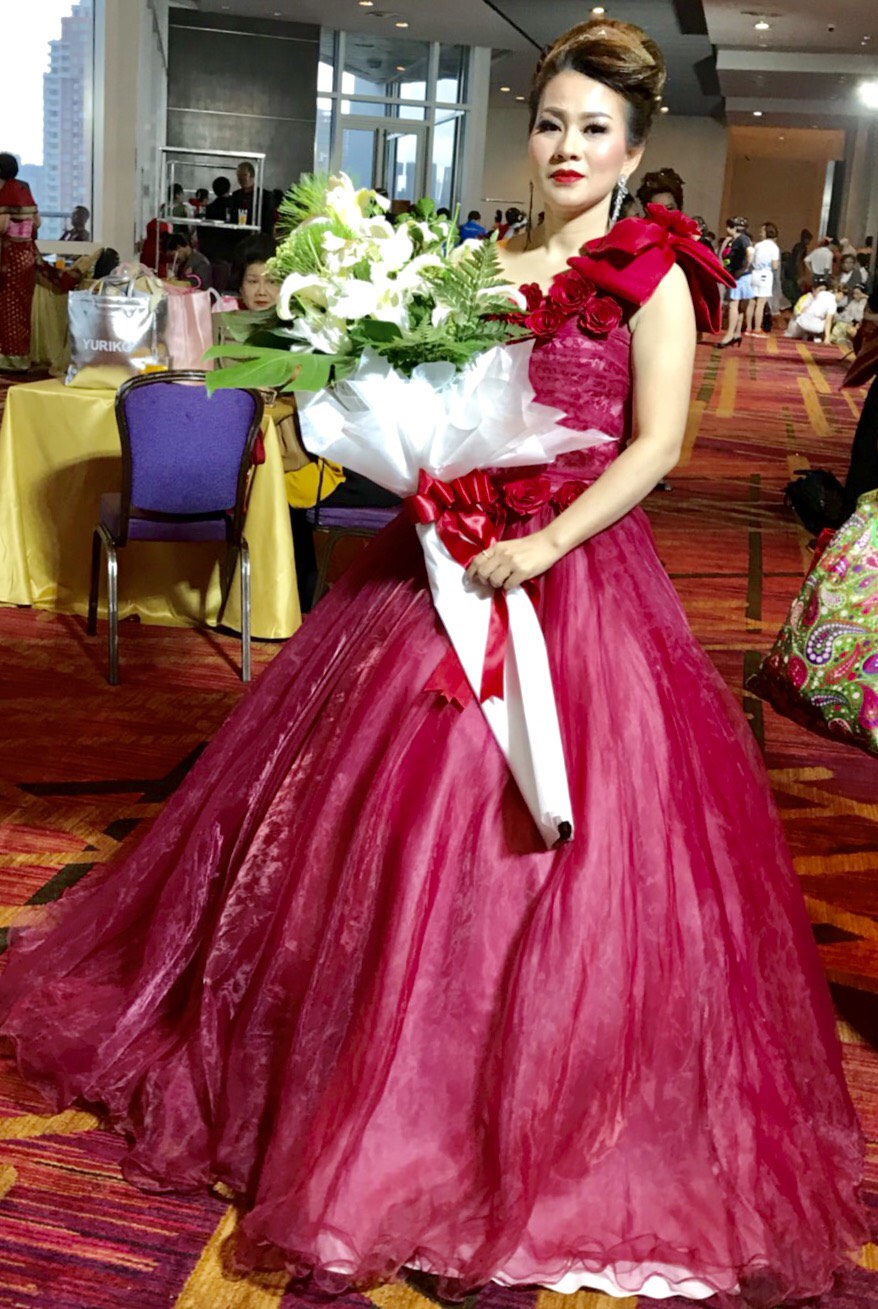 พร้อมเช่า ชุดแฟนซี ชุดราตรียาว สีแดง ไหล่เฉียง ตัวชุดเป็นผ้าแก้ว แต่งดอกสวย ไหล่ซ้ายมีโบว์ เชือกผูกหลัง