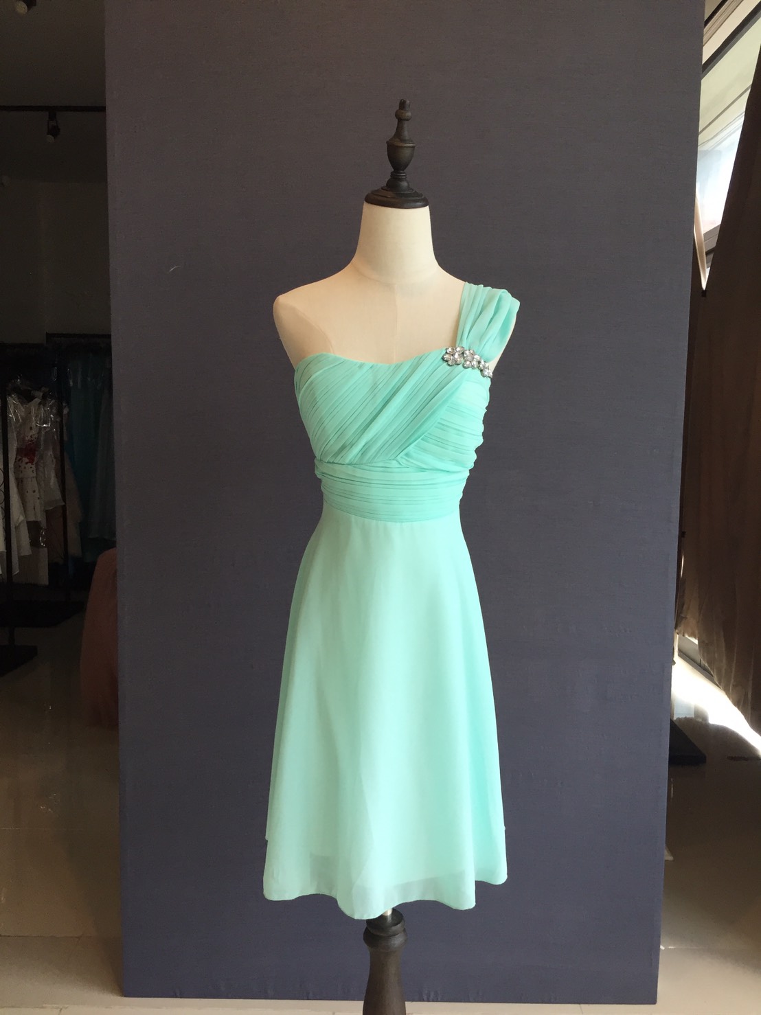 พร้อมเช่า ชุดราตรีสั้น ชุดเพื่อนเจ้าสาว สีเขียวมิ้นต์ ผ้าชีฟอง แบบ A ไหล่เดียว อกจับจีบ แต่งคริสตัลอกซ้าย (เชือกผูกด้านหลัง)