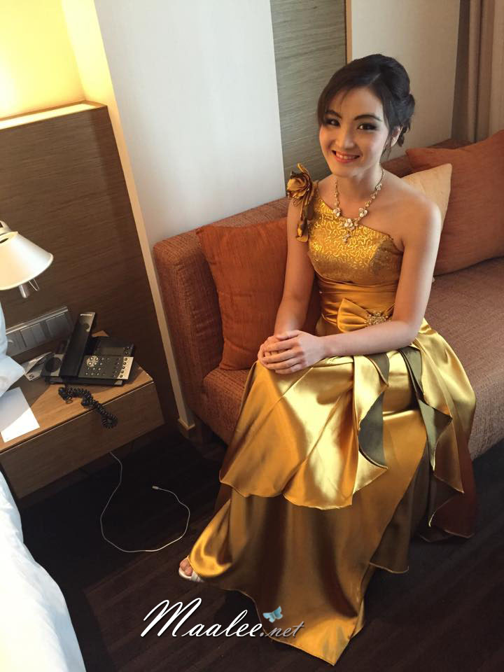 พร้อมเช่า ชุดราตรียาว ไหล่เฉียง สีทอง ปักเลื่อมไล่สี จับจีบแต่งโบว์ช่วงเอว ประดับดอกไม้สวยหวานบนไหล่