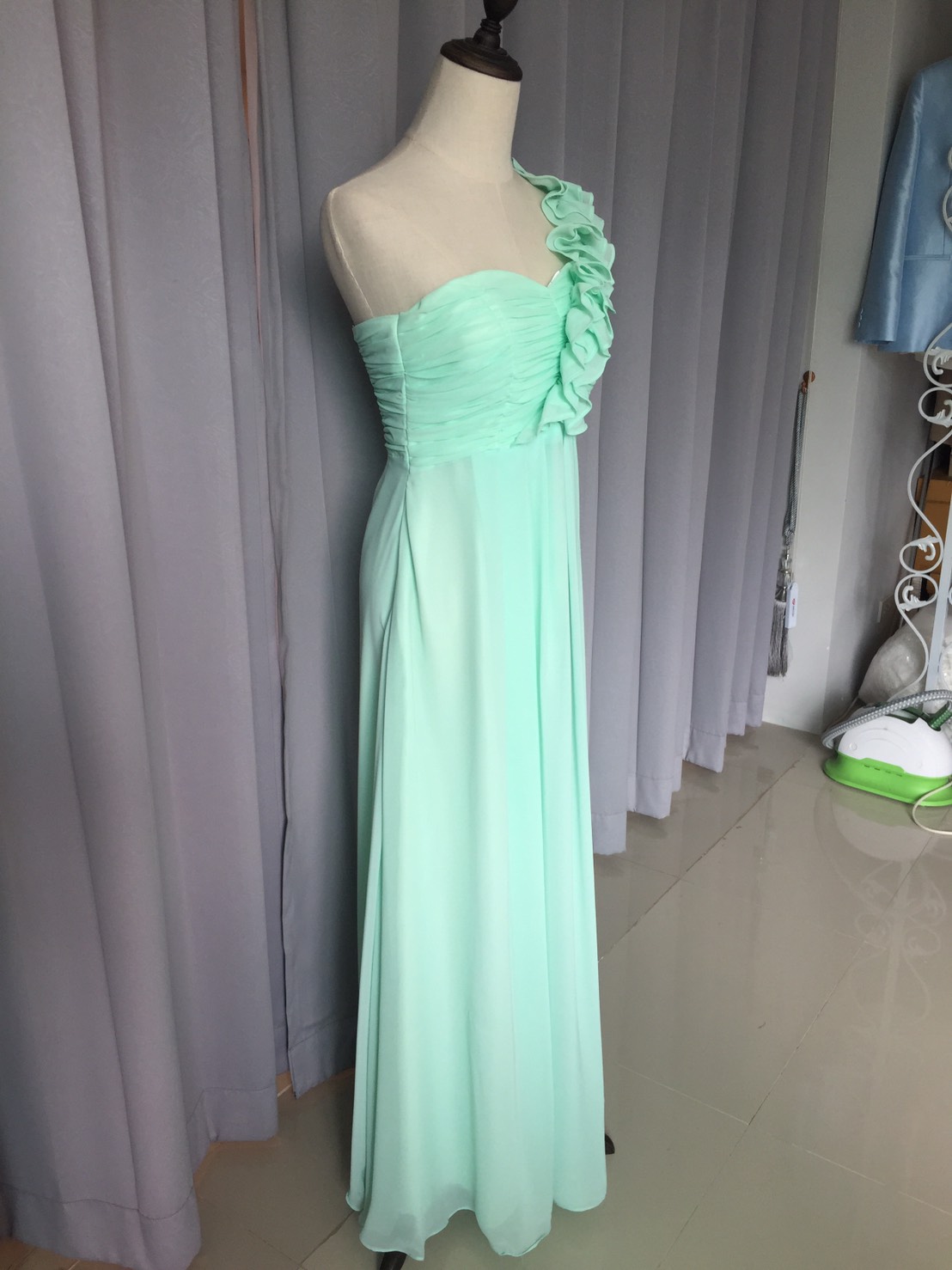 พร้อมเช่า ชุดราตรียาว ไหล่เดียว จับเดรปหน้าอก แต่งระบายช่วงไหล่ สีเขียวอ่อน