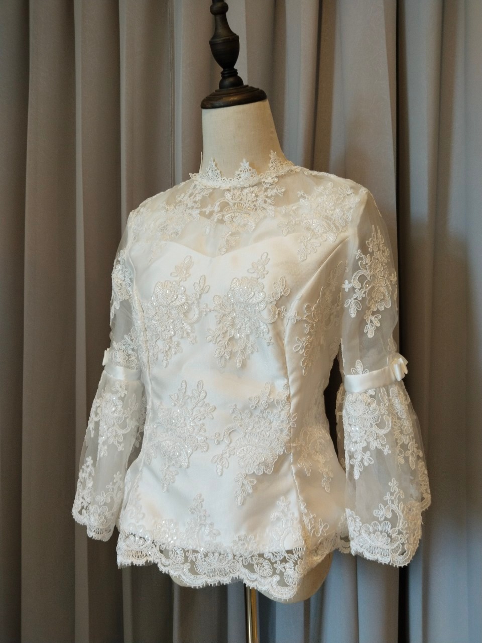 พร้อมเช่า เสื้อลูกไม้สีขาว คอปีน แขนยาวแต่งระบายคาดโบว์ ซิปหลัง (เฉพาะเสื้อ)