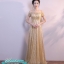 พร้อมเช่า ชุดราตรียาว แบบไหล่ปาดแขนสั้น สีทอง แต่งเม็ดกากเพชรทั้งชุด มาพร้อมเข็มขัดรูปใบไม้สีทอง หรูมาก